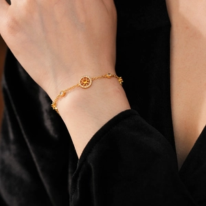 Detailed macro view of a gold starburst compass bracelet with yellow and white zircon gems