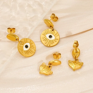 Détail de boucles d'oreilles en émail doré avec motifs yeux et tête de renard chic