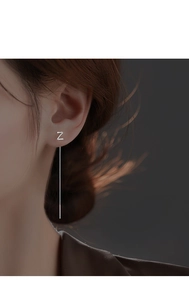 Detail of silver long chain earring with Z letter pendant showing vertical drape on ear