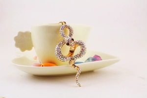 Close-up of golden snake keychain with sparkling rainbow rhinestones and crystal eyes
