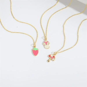 Golden necklaces with cute enamel strawberry and mushroom pendants on a white background
