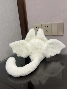 Detail of soft plush white wings and tail accessory with a fluffy long fur texture