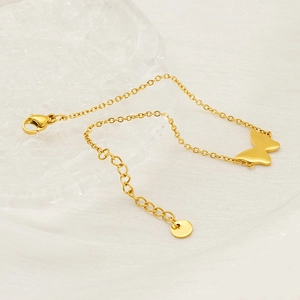 Minimalist gold-plated stainless steel butterfly charm bracelet on white fabric background