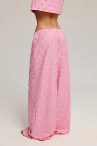 Détail du tissu floqué à cœurs roses sur le haut court et le pantalon de pyjama