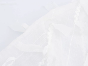 Close-up of white fabric texture featuring elegant leaf-shaped fringe design details