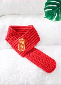 Vue détaillée d'une écharpe tricotée rouge pour animaux avec broderie dorée porte-bonheur