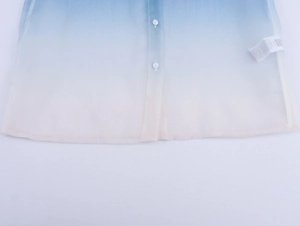 Close-up of floral organza shirt hem showing blue gradient fabric and buttons
