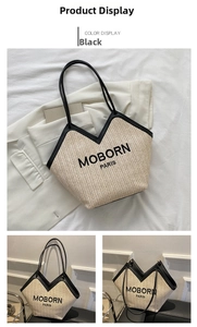Detail view of woven straw tote bag with black PU handles and Moborn Paris logo lettering