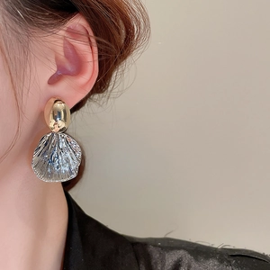 Vue rapprochée de boucles d'oreilles ovales bicolores avec finition dorée et argentée