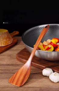 Detail of solid ebony wood spatula with natural grain and ergonomic long handle