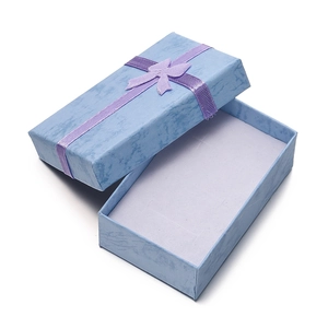 Macro shot of light blue jewelry gift box with textured paper and purple ribbon bow