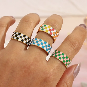 Detail of 18K gold plated checkerboard enamel rings in diverse vibrant colors on model's hand