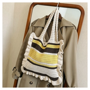 Detail view of handmade knitted tote bag with yellow and brown stripes and ruffle trim