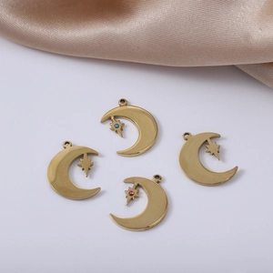 Detailed view of four golden moon and star pendants with colorful gems on silk fabric