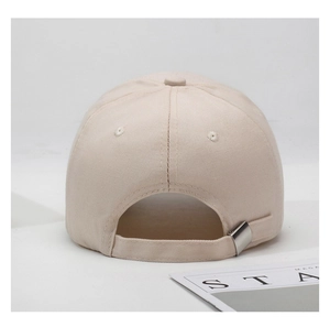Close-up of adjustable metal buckle and cotton twill texture on beige baseball cap