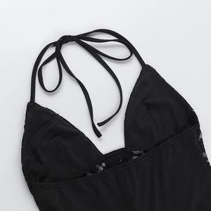 Close-up of black lace halter neck detail and slim straps on a sleek jumpsuit