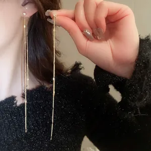 Elegant long gold tassel earrings with round cubic zirconia studs for a minimalist style