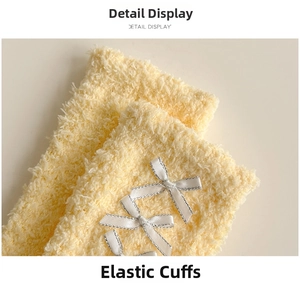 Close-up of elastic cuff on fuzzy yellow coral fleece socks with white satin bows