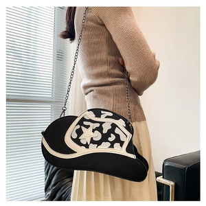Detail of cowboy hat-shaped crossbody bag featuring cow print pattern and white star detail