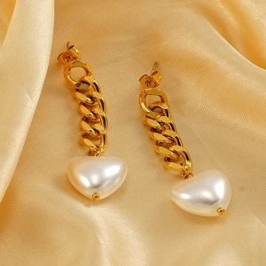 18K gold plated chain earrings with pearl heart pendants on silk fabric background