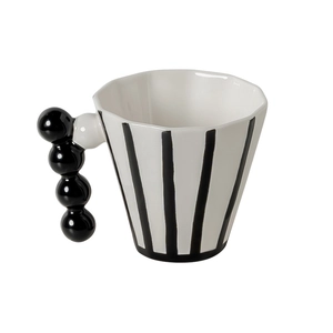 Modern minimalist white ceramic coffee mug with black stripes and beaded handle design