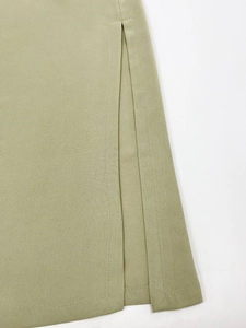 Detail des salbeigrünen Kleid-Saums mit Seitenschlitz und präziser Doppelnahtführung