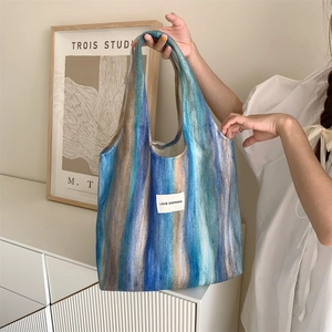 Détail du sac cabas en laine rayé avec étiquette LOVE SOZAKKA dans un intérieur