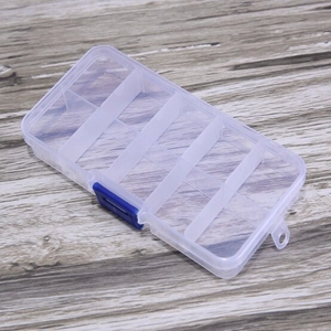Macro shot of 10-compartment transparent plastic jewelry storage box with blue buckle latch