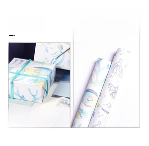 Detail of ocean series gift wrapping paper with fish patterns and blue coral motifs