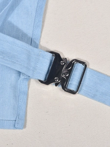 Gros plan détaillé du tissu en denim bleu clair et de la boucle métallique cobra