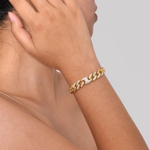 Detail eines goldenen Panzerarmbands mit Zirkonia-Blatt und Unendlichkeit-Herz-Anhänger