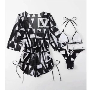Detailed flat lay of three-piece black and white geometric print bikini with mesh cover-up