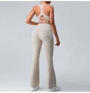 Detail of cross-back yoga top and high-waisted flare leggings in beige stretch fabric
