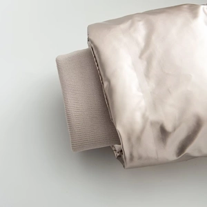Detailed close-up of ribbed windproof cuffs on a glossy champagne hooded ski jacket