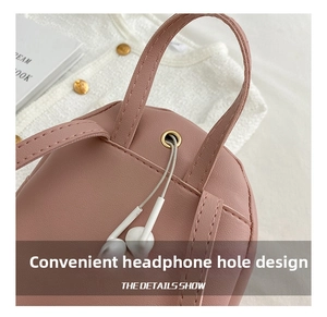 Detailed macro view of a pink leather small backpack featuring a golden metal headphone jack