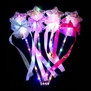 Detail of four colorful LED star magic wands with mesh lace and ribbons on black background