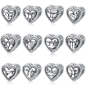 Set of twelve heart-shaped silver zodiac charms with black enamel astrological symbols