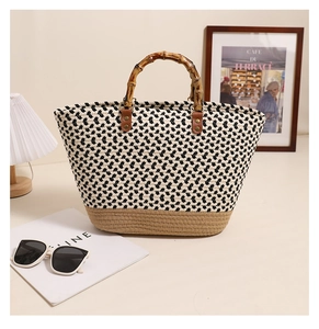 Detail of hand-woven tote bag featuring a bamboo handle and monochrome pattern textures