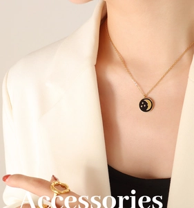 Detail of 18k gold star and moon pendant necklace with minimalist irregular ring