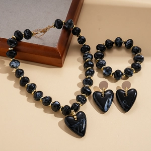 Detail of heart necklace set with black marble acrylic beads and golden spacers