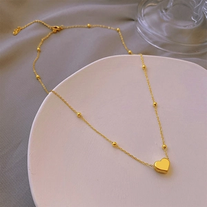 Minimalist 18K gold plated titanium heart pendant necklace with beaded chain on display
