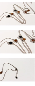 Detail view of silver twisted chain with black enamel round pendants and lobster clasp