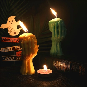 3D skull hand silicone mold for Halloween candles in yellow and teal on dark background