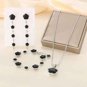 Detailed set of clover jewelry with black charms, long tassel earrings, and silver chain