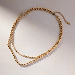 Detailed close-up of golden stainless steel double-layered bead chain necklace
