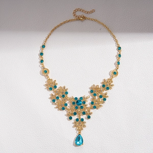 Detailed view of vintage gold floral necklace with blue zircon teardrop pendant charms