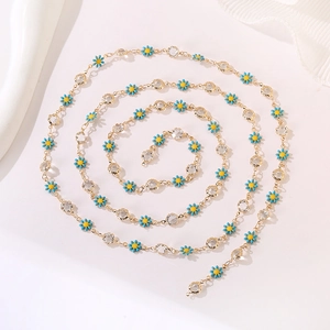 Detailed macro view of golden chain with blue enamel daisies and sparkling crystals