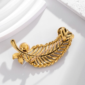 Vintage gold leaf brooch with elegant pink pearl accent and detailed metal texture