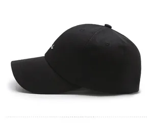 Detail of white letter embroidery on a black cotton baseball cap with curved brim