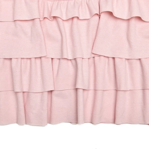 Détail macro du tissu en maille côtelée rose avec texture de volants multicouches